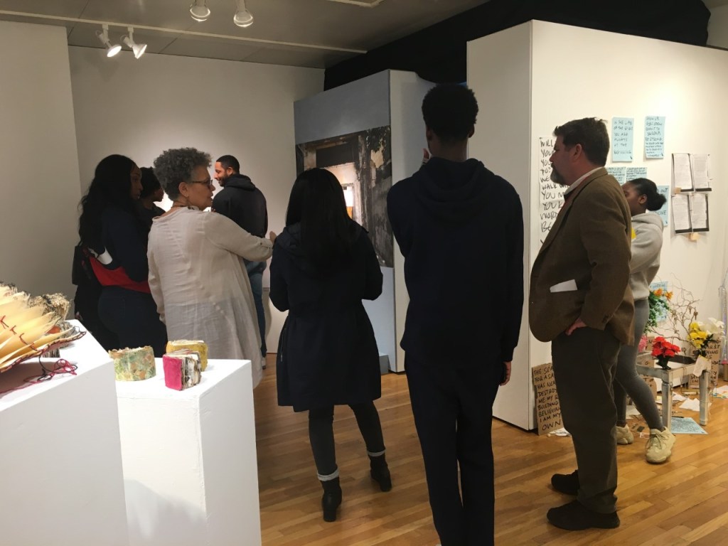 A group of people standing in a room

Description automatically generated